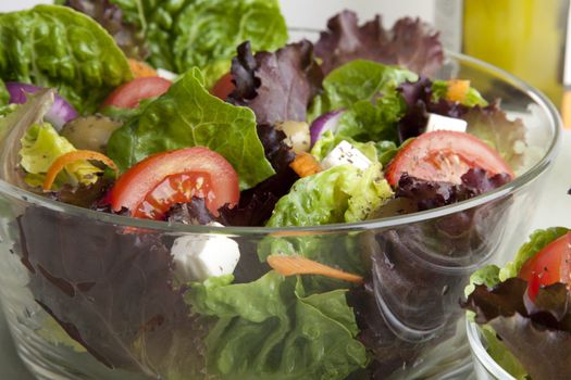 Glass serving bowl of fresh green salad.