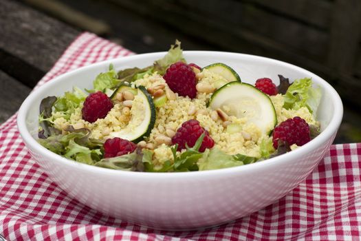 Couscous salad with zucchini and raspberries and pine nuts.