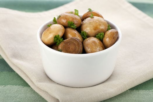 Fresh marinated mushroom tapas in white bowl.