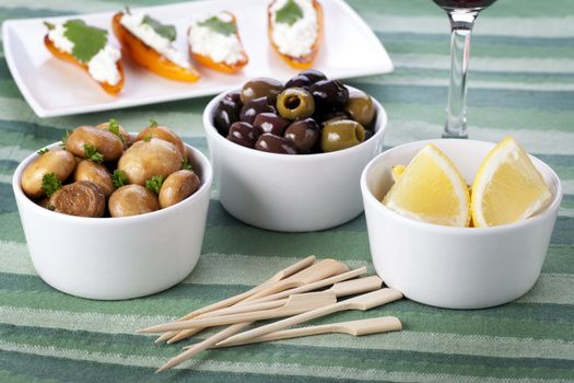 Mushroom and olive tapas with lemon wedges