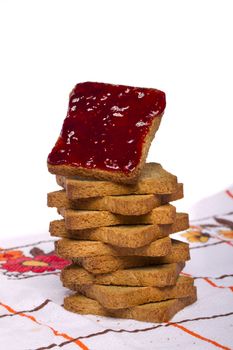 Close view of a toasted bread with berry jam isolated on a white background.