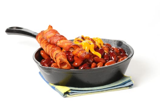 Baked beans and bacon served in a cast iron skillet.