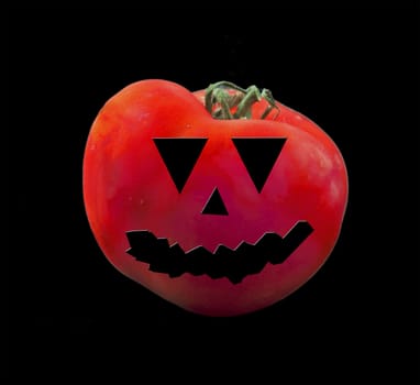 A tomato with eyes and grin of an Halloween pumpkin