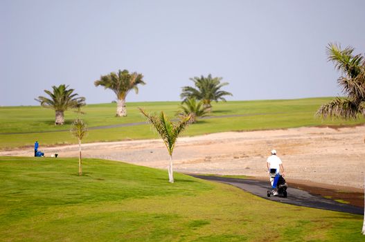 Golfer walking at path to next hole