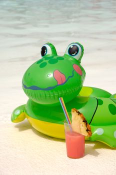 Happy frog is enjoying a cool drink by the pool