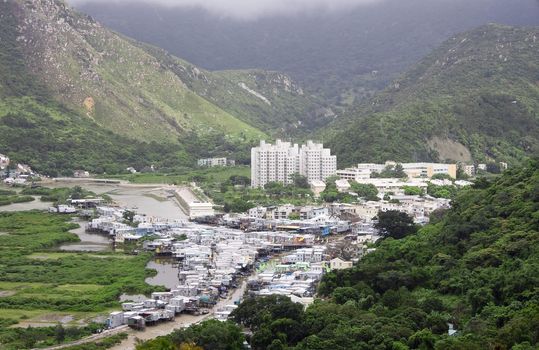 Small fishing village at a base of a high mountain,hong kong