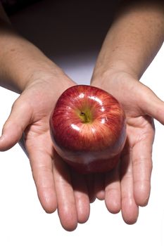 Woman holding fresh apple from dark to light for texture