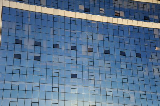 Detail of a glass-fronted office block with contents of offices faintly visible behind the glass. Suitable as abstract background.