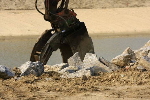 buck hoe  construction equipment working on a river dike.