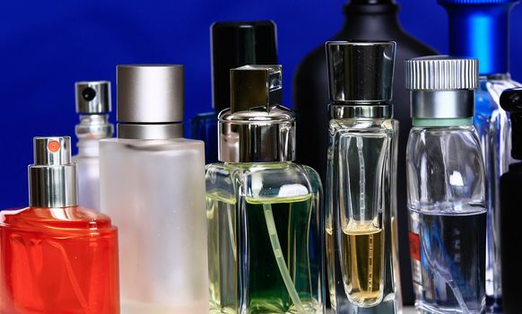 Fragrance and perfume bottles in navy blue background.