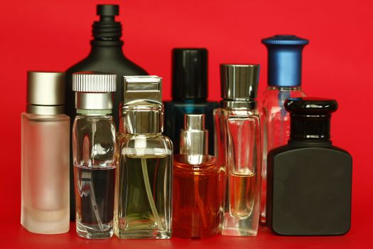 Perfume and fragrances bottles in red background.