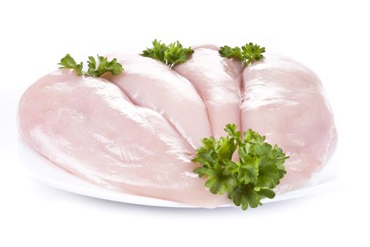 Raw chicken breast on the plate with parsley - isolated