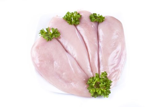 Raw chicken breasts on the plate with parsley - isolated