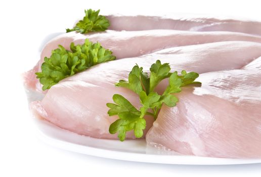 Raw chicken breasts on the plate with parsley - isolated