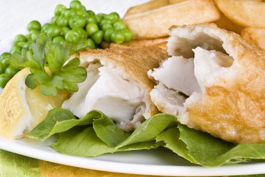 Fried fish and chips with lemon and peas