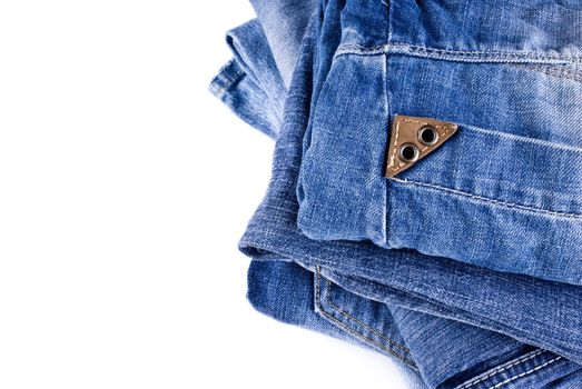 stack of various shades of blue jeans over white background