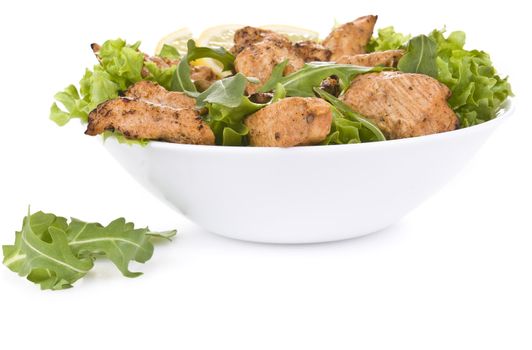 Chicken salad with dropped leaves over white background