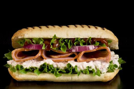 Ham and vegetable sandwich on a black background