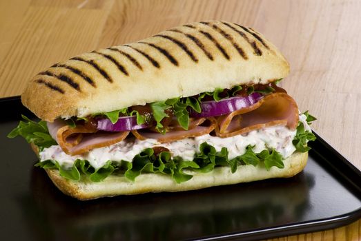 Ham and vegetable sandwich on a black tray
