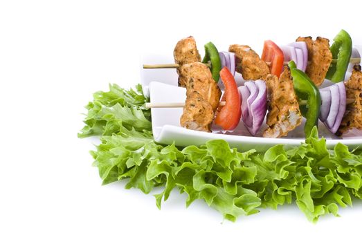 Skewers with chicken and vegetables on the plate - isolated