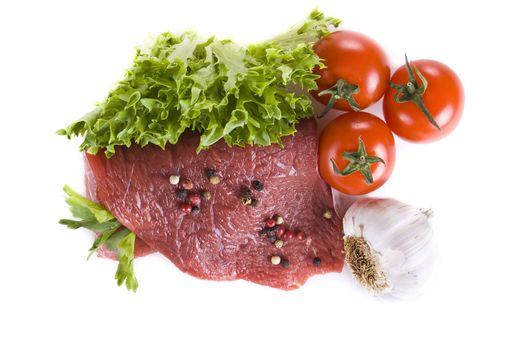 Raw beef frying steak with vegetables isolated over white background