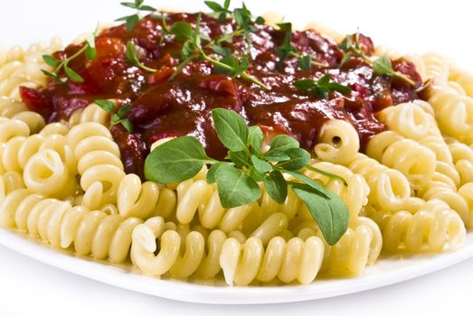 Fusilli pasta with tomato and vegetable sauce over white background
