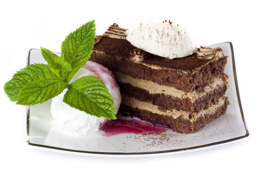 Tiramisu cake on plate with ice cream isolated over white