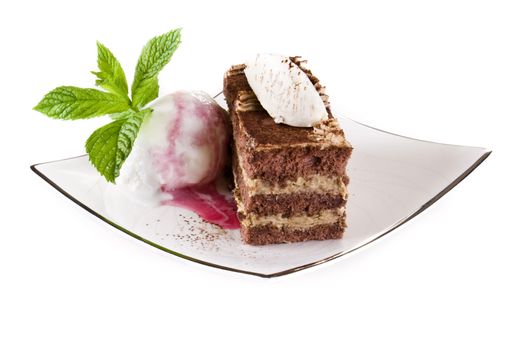 Tiramisu cake on plate with ice cream isolated over white