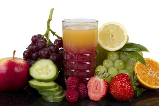 Fruits and cucumber juice in black reflection