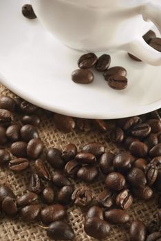closeup of coffee beans around cup of coffee