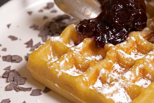 Freshly prepared belgian waffle with raspberry marmelade