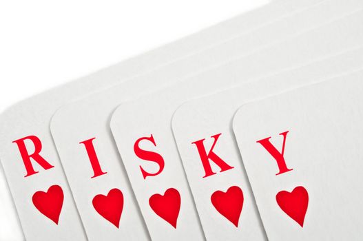 A selection of playing cards spread over white to reveal the word 'RISKY'