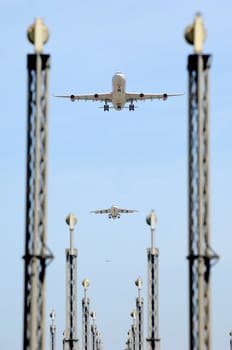 Planes are flying over landing lights in an airport