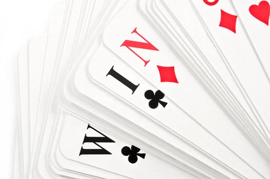 Close up on a deck of spread playing cards revealing the word 'WIN' over white