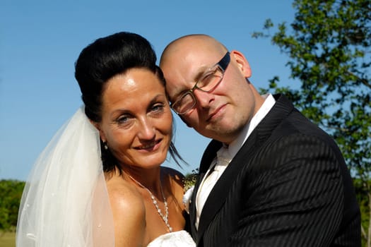 A very happy wedding couple standing close together.