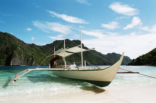 philippines tranditional boat, banca, docked  at shore.