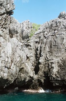 A limestone cliff on sea, waves are hitting against it.