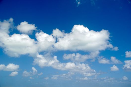 Cloudscape with white cumulus clouds and a blue sky.