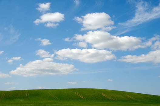 Landscape with green hill and clouds