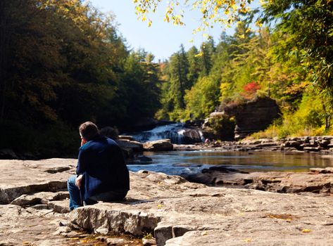 Lady watching the upper falls in Swallow Falls State Park in Maryland USA