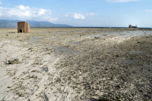 Low tide in shoreline with a cabin and an aground boat