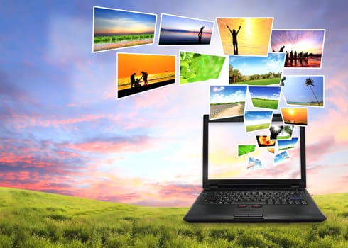 Multimedia concept with modern laptop on green field