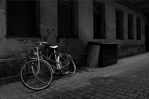 Vintage bikes over old wall. Black and white.