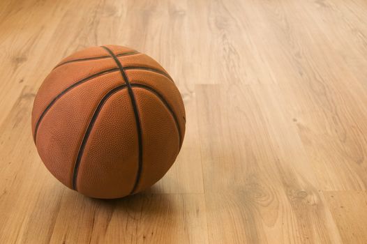 Basketball over wooden floor. Close up.