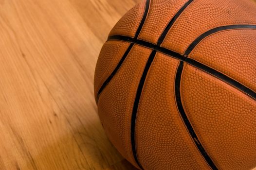 Basketball over wooden floor. Close up.