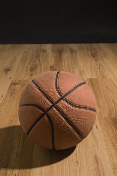 Basketball over wooden floor. Close up.