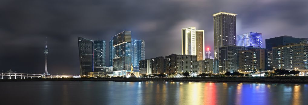 Panoramic cityscape in night with skyscraper and buildings and river in Macao, China.