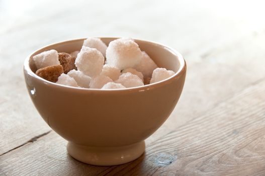 Brown and white sugar cubes in a bowl