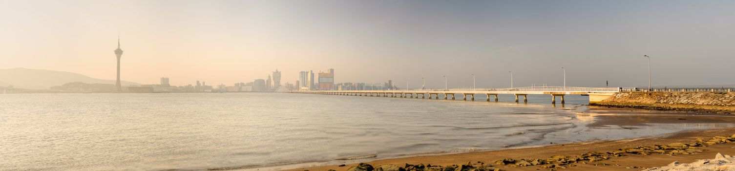 Panoramic cityscape of sunset with buildings, bridge and river in Macao, China.
