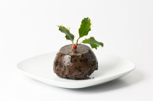 Traditional english Christmas pudding with holly leaves